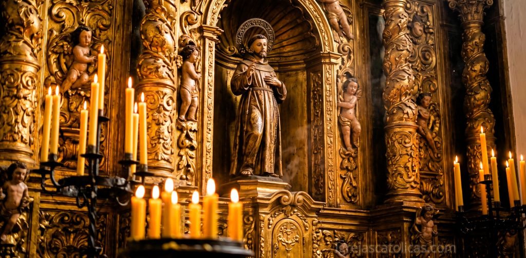Detalhe de altar barroco com talha dourada e imagem de santo iluminada por velas